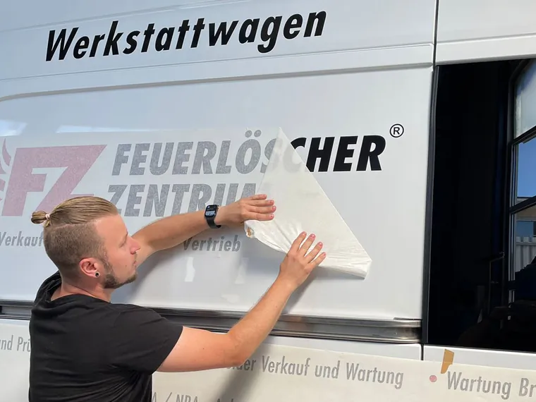 Paul Kehm bringt die Beschriftung auf den Werkstattwagen des FZ Feuerlöscher Zentrums auf