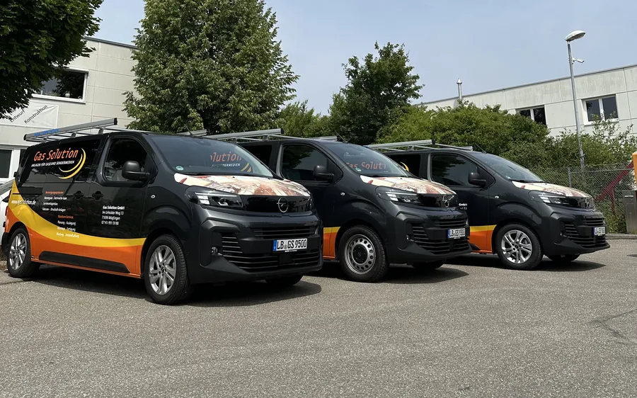 Drei identisch beschriftete Transporter von Gas Solution nebeneinander, alle mit derselben Chromfolie auf der Motorhaube