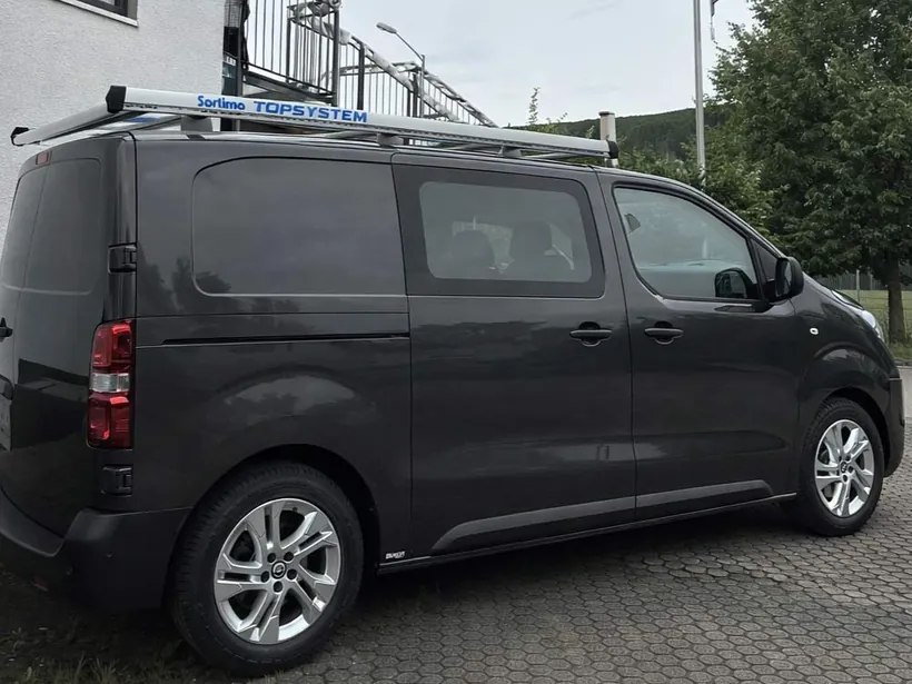 Unbeklebter dunkler Transporter von Gas Solution vor der Fahrzeugbeschriftung bei Anker Werbung