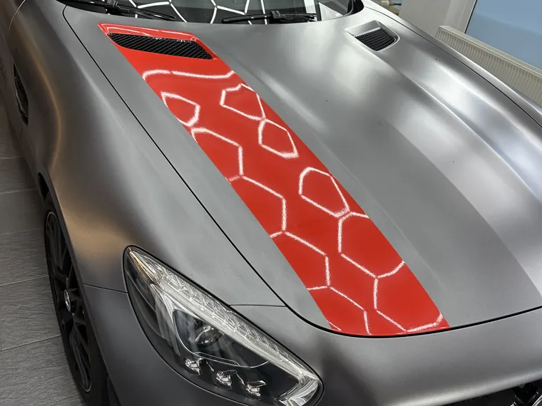 Mattgrauer Mercedes-AMG mit roter Wabengrafik auf Motorhaube und Flanke, Teilfolierung von Anker Werbung
